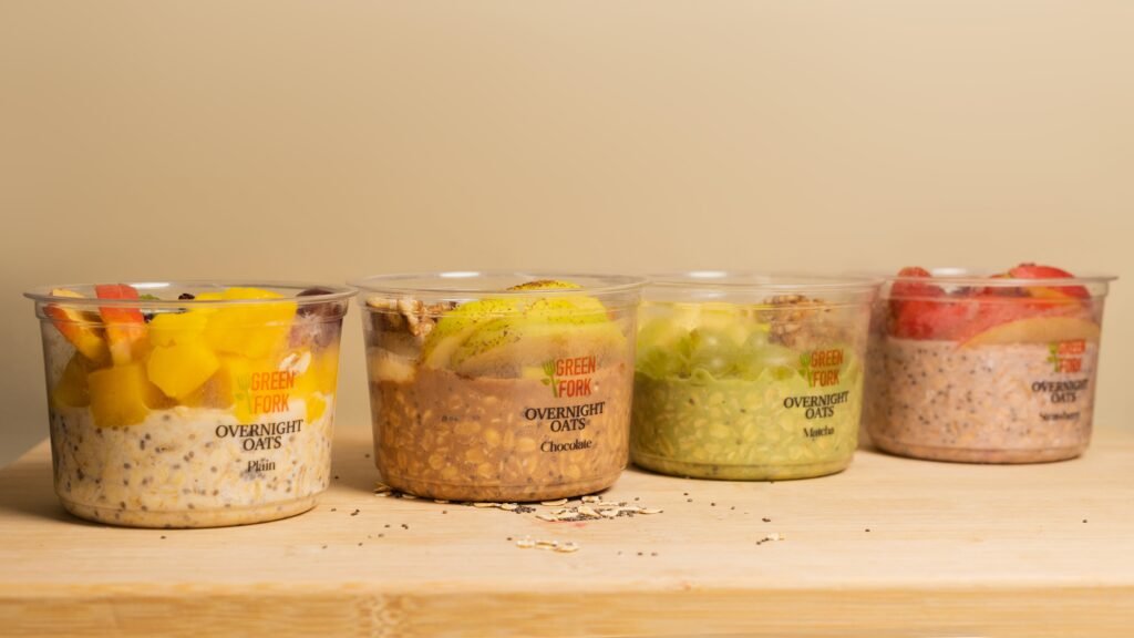 Four Greenfork overnight oats cups lined up on a counter