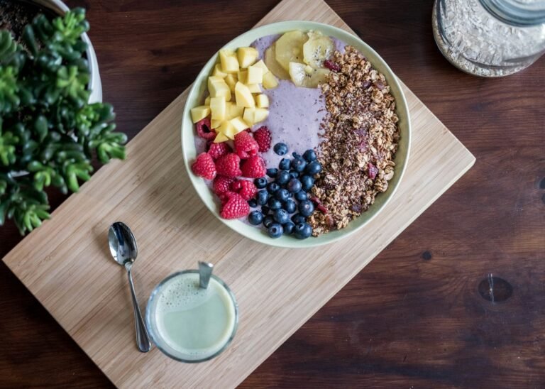 A prepared breakfast bowl of oats and fresh fruit on a wooden board