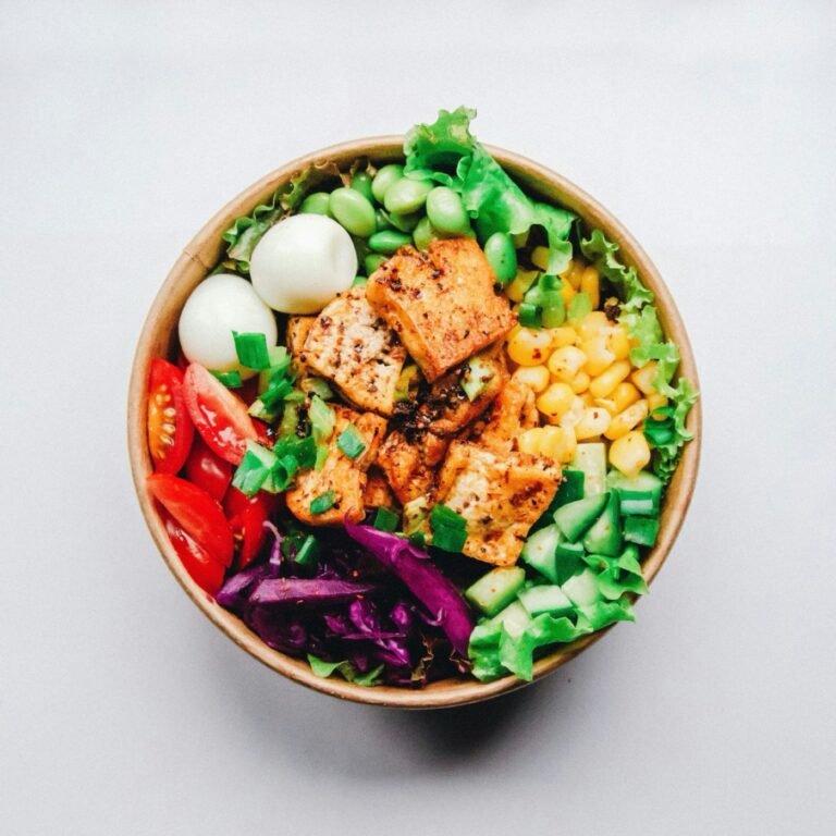 An overhead view of a salad bowl of grains, vegetables and greens